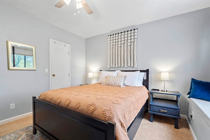 Enjoy comfort in the second bedroom with a queen-sized pillow-top mattress. The custom-made window seat provides a cozy spot with a backyard view, complemented by room-darkening curtains for a restful ambiance.