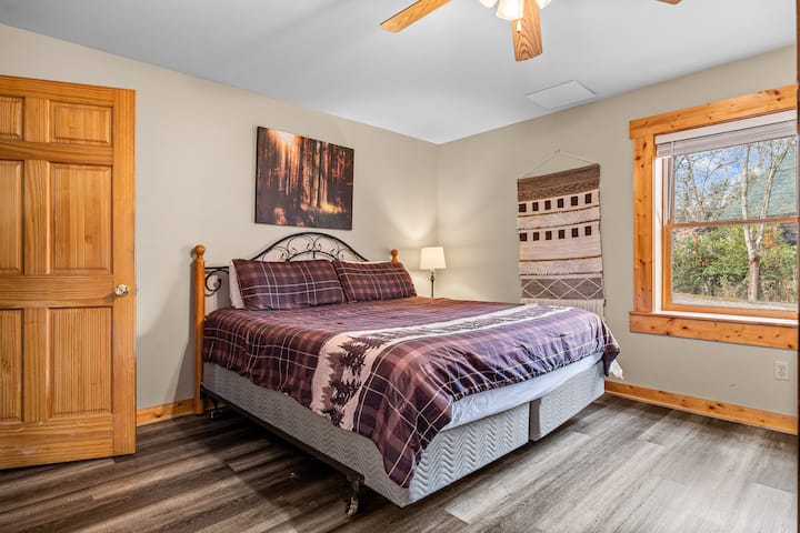 საძინებელი: კომფორტული საძინებელი რბილი თეთრეულითა და ბუნებრივი სინათლით — იდეალურია დასასვენებლად.