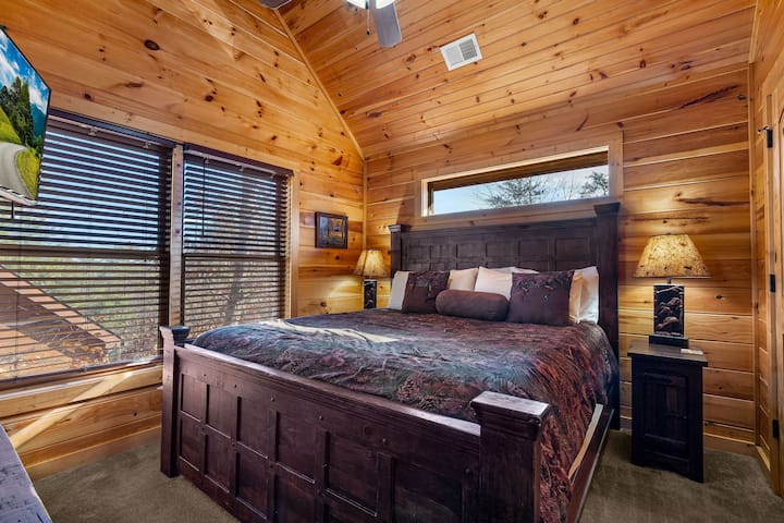 غرفة نوم علوية – غرفة نوم علوية مشرقة مع سرير كينج ونوافذ كبيرة وإطلالات على الغابات، مما يوفر مكانًا هادئًا للاسترخاء في سموكي.