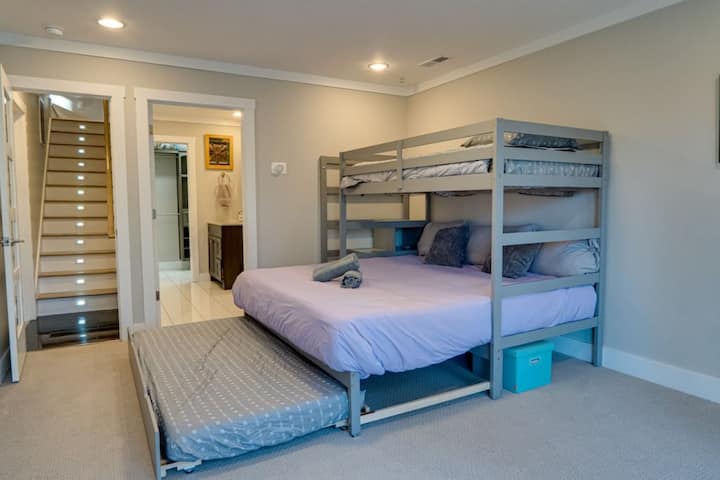 سرير كبير في الطابق السفلي مع سرير مزدوج وسريرين مزدوجين. يمكن سحب تراندل ووضعه في مكان مختلف في جميع أنحاء الغرفة.