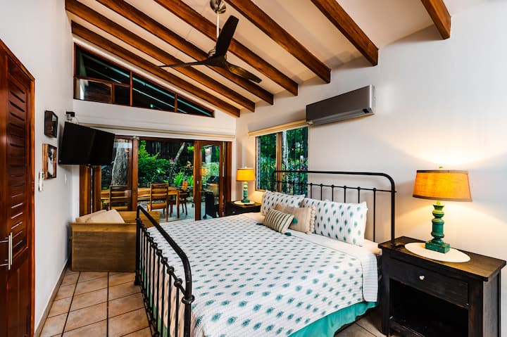 Master bedroom suite featuring a king-size bed and flat-screen TV, designed for comfort and relaxation in your Tamarindo beach cottage.