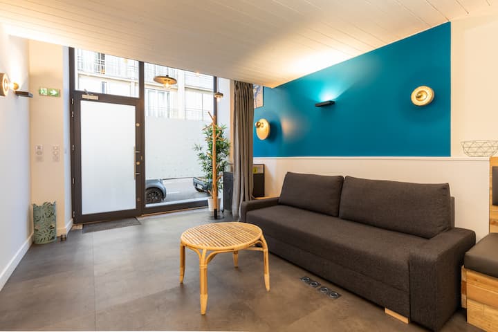 ห้องนั่งเล่นที่อบอุ่นพร้อมเครื่องปรับอากาศพร้อมเตียงโซฟา โต๊ะข้าง ทีวี และโต๊ะรับประทานอาหารสำหรับ 4 คน