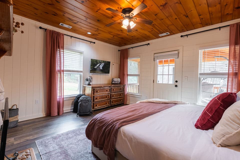 The primary bedroom's king bed, morning light easing you awake