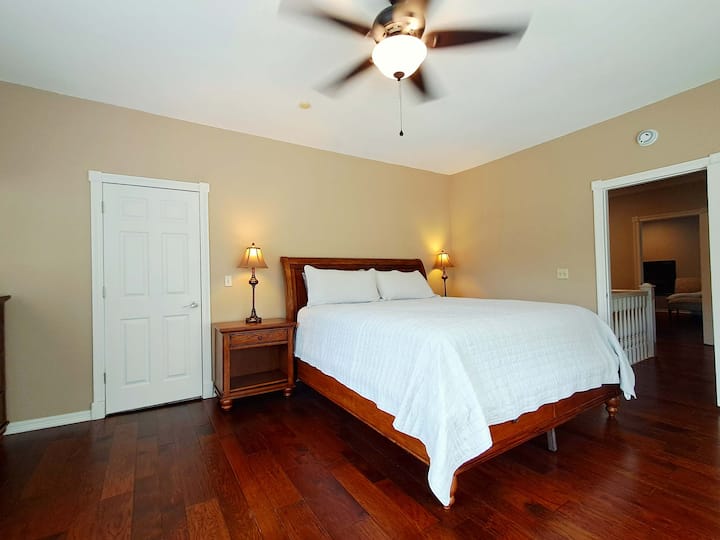 Chambre d'invité rénovée avec un nouveau très grand lit, des draps frais et des meubles pour un séjour confortable.