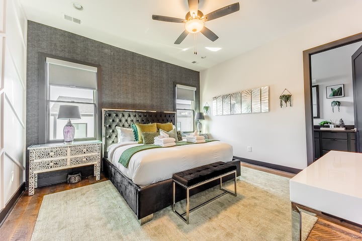 غرفة نوم أساسية بها سرير كينج وأثاث مصمم وتلفزيون ذكي وحمام داخلي.