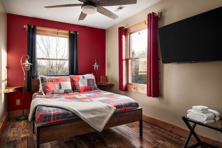 La habitación roja tiene encanto de cabaña con una cómoda cama tamaño queen y TV, acomódate después de un día en los senderos o bodegas.
