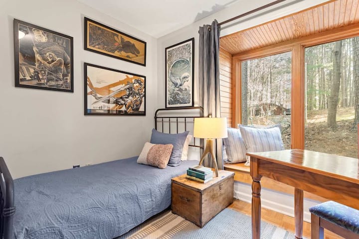 Vista del dormitorio cuatro con cama doble, zona de lavandería y espacio de oficina en casa ubicado en esta habitación.  Este dormitorio está en el sótano de la casa. 