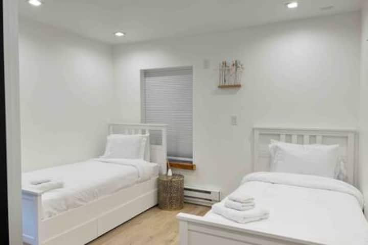 Dormitorio en el nivel inferior con dos camas individuales y almacenamiento