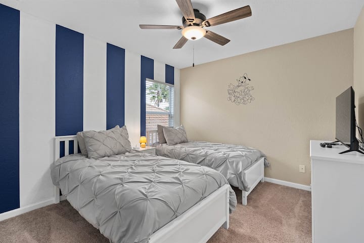 Спалня на горния етаж с две единични легла, със забавни морски щрихи на Доналд Дък.