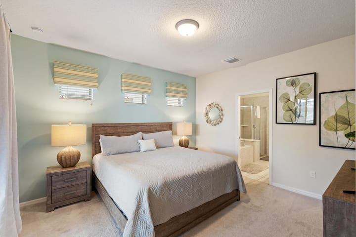 غرفة نوم رئيسية تضم سرير كينج في الطابق السفلي، وحمام ملحق وتلفزيون ذكي 43 بوصة