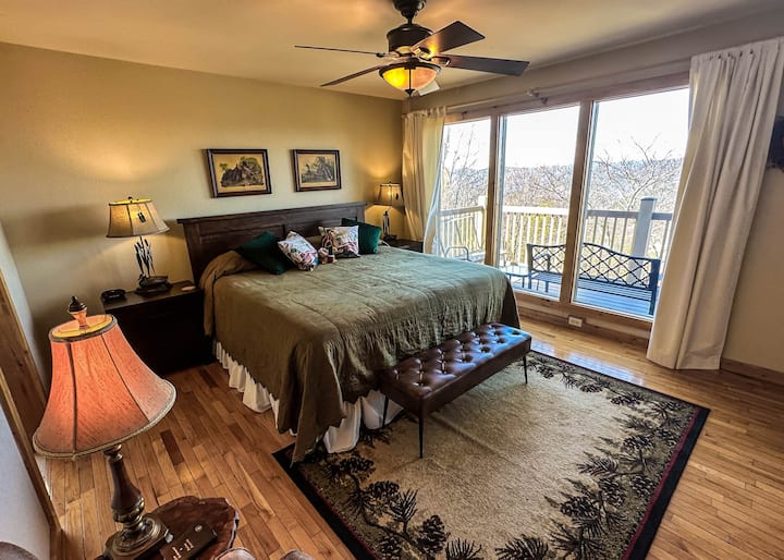 Suite con cama tamaño king en segundo/nivel principal con vistas al atardecer sobre Chilhowee Mtn.
