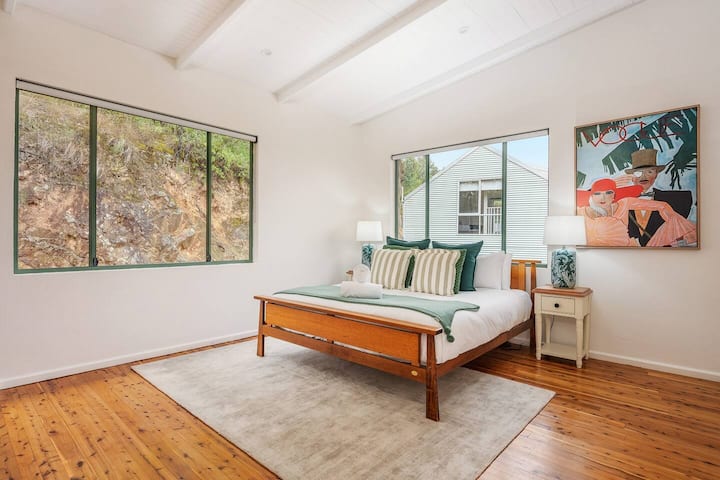 Glavna spavaća soba s raskošnim bračnim krevetom veličine king i vlastitom kupaonicom nudi prekrasan pogled na krošnje drveća.