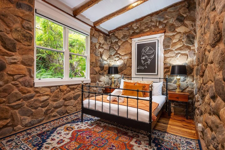 Četvrta spavaća soba ima bogate teksture s bračnim krevetom, noćnim ormarićima i svjetlima za čitanje.
