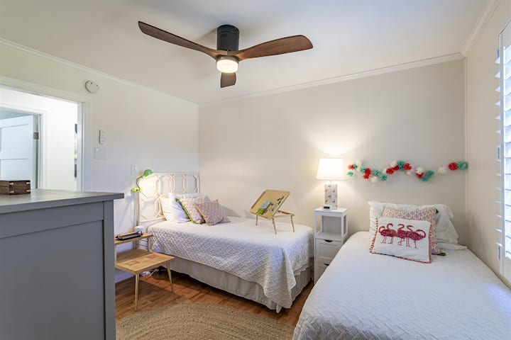 Chumba kitamu cha kulala chenye vitanda viwili pacha. Kila chumba cha kulala kina feni ya dari iliyo na rimoti.