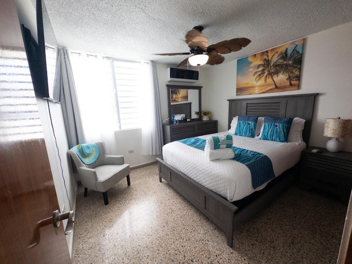 1st Bedroom: Relax in style with ocean views, 55" TV, and vibrant beach-themed decor!