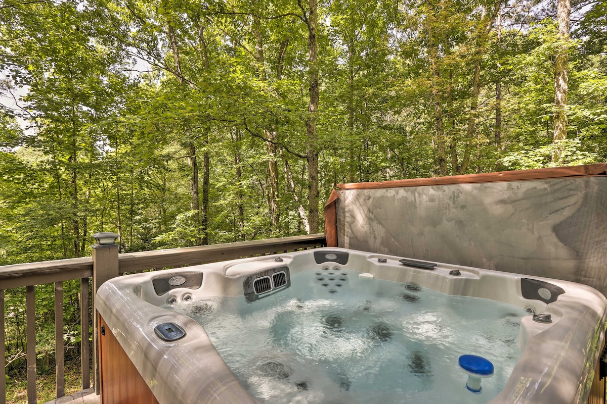 A private hot tub is positioned on the deck, surrounded by lush trees. The bubbling water hints at a relaxing atmosphere, while the wooden railing adds a natural touch to the serene forest view.