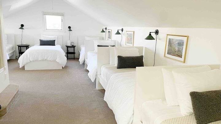 In the L-shaped bunk room, 4 beds are “head to toe” with 2 more side by side on the window wall.