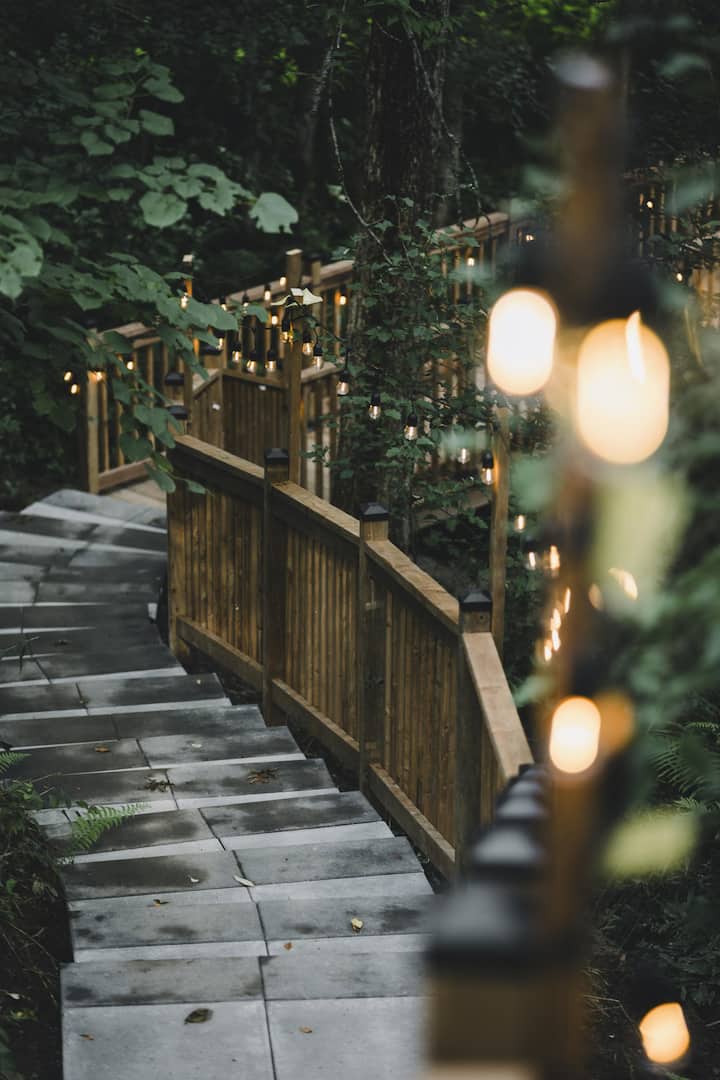 The cottage’s outdoor staircase surrounded by trees and string lights
