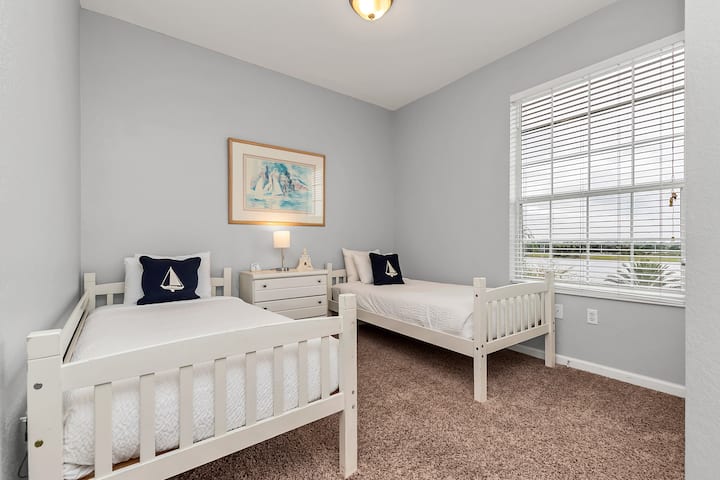 在我们位于奥兰多公寓的舒适卧室中放松身心-专为二人组合设计，配备两张单人床-提供舒适时尚的度假胜地-地毯宽敞-窗户明亮通风，景色迷人