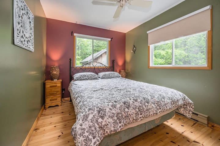 Პირველი სართულის საძინებელი Queen ‑ ის ზომის საწოლით, კომფორტული ზეწრებითა და შესანიშნავი ხედით.