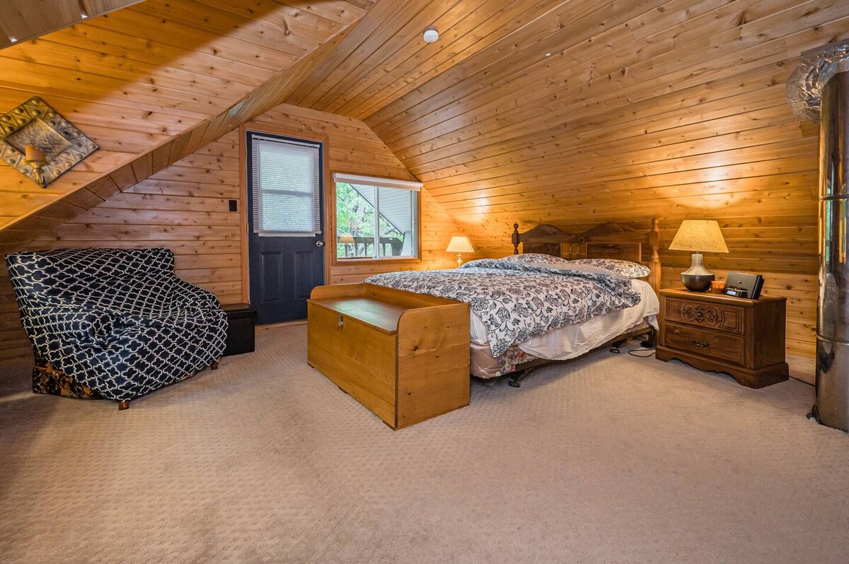 El dormitorio principal cuenta con sábanas suaves y esponjosas con un ambiente clásico de cabaña a tu alrededor. 