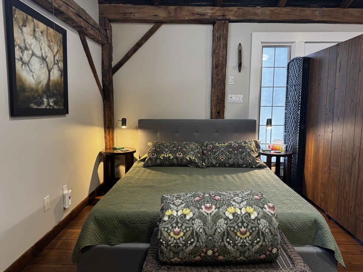 Comfortabel queensize bed in loftachtige ruimte op de bovenverdieping