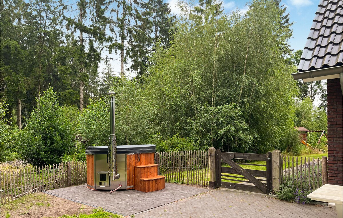 An outdoor area is highlighted, featuring a hot tub adjacent to a wooden deck. A natural wood fence surrounds the space, providing privacy. Lush greenery and trees create a serene backdrop, enhancing the connection with nature.