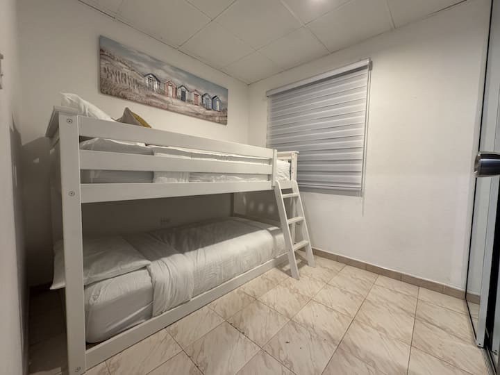 Cozy bunk room with clean linens, tile floors & blackout shade