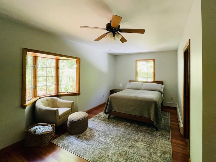 宽敞的主卧设有一张1.8米宽双人床、一个舒适的书籍角落，光线充足。 卧室面朝森林，景色绝佳。 图片是主卫生间的门。