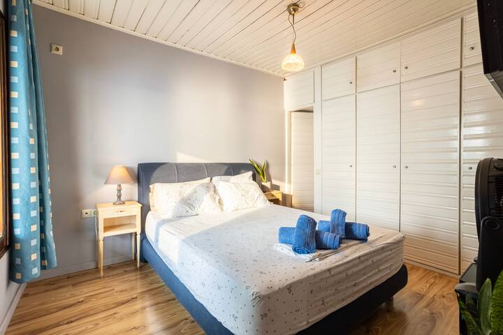 غرفة النوم 1 • سرير كينج وخزائن ملابس مدمجة وإطلالة على الحديقة
