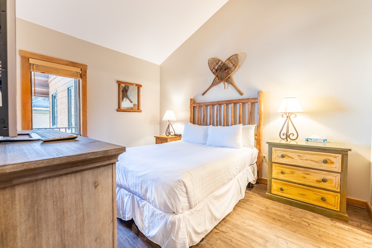 Glavna spavaća soba s bračnim krevetom, televizorom ravnog ekrana i kupaonicom u sobi. 