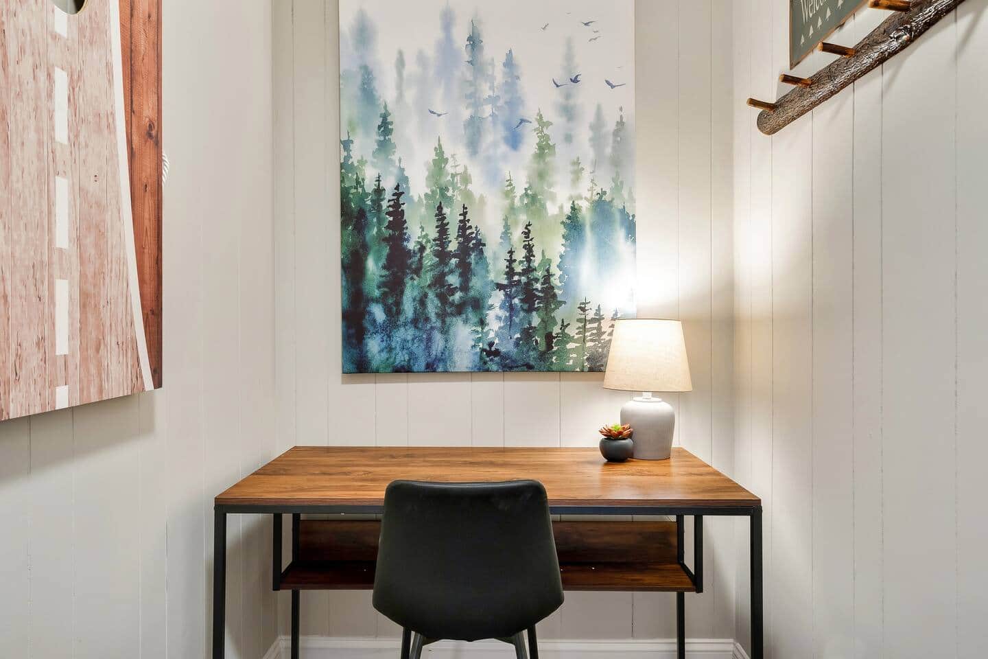 The dedicated workspace with desk, chair and forest artwork
