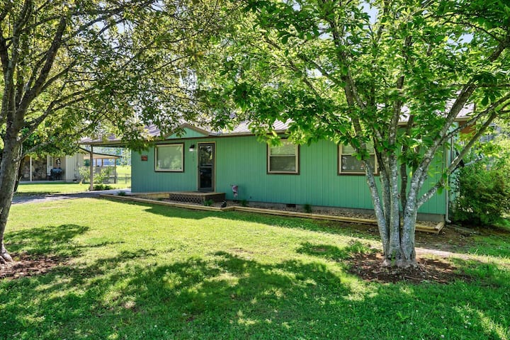 The Asbeary Cottage exterior, a single-level cottage under a large shade tree