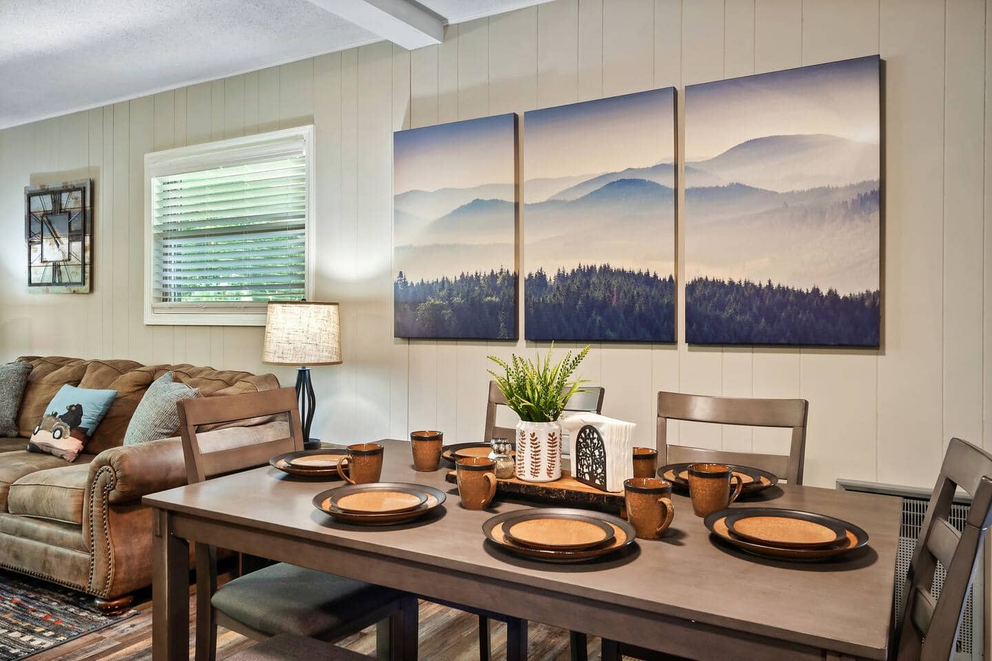 Dining table seating six beneath mountain artwork