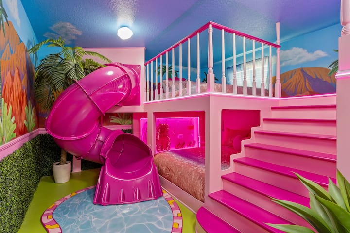 Our Barbie-themed bedroom features 4 queen-sized beds with an indoor slide spiraling down from a lofted bed area, perfect for kids and the young at heart.