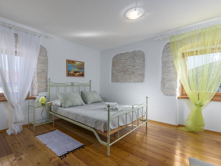 La interacción de colores sutiles resalta la belleza de las antiguas paredes de la villa en este hermoso dormitorio.