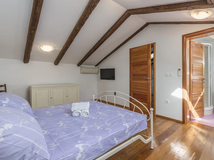 Experimenta una serenidad maravillosa en el cómodo dormitorio con temática de lavanda de Villa Katarina, donde la relajante paleta de colores crea un ambiente tranquilo y acogedor en el espacio con aire acondicionado.