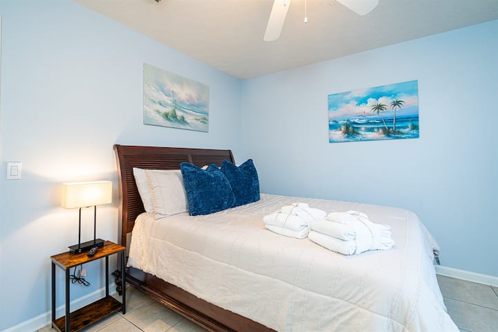 Dhoma e gjumit: Çlodhu në këtë hapësirë të qetë me dekor plazhi dhe një krevat dopio "queen" që të pret!