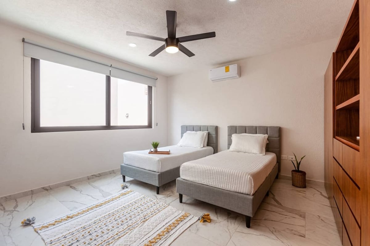 Chumba cha kulala cha Mtu Binafsi Mara Mbili kilicho na magodoro mapya, feni ya AC na dari. Mapazia ya kuzima yanahakikisha kupumzika ikiwa wewe ni mmoja wa wale wanaopenda kuamka kwa kuchelewa. Ina kabati kubwa na bafu zuri la kujitegemea kwa ajili yako