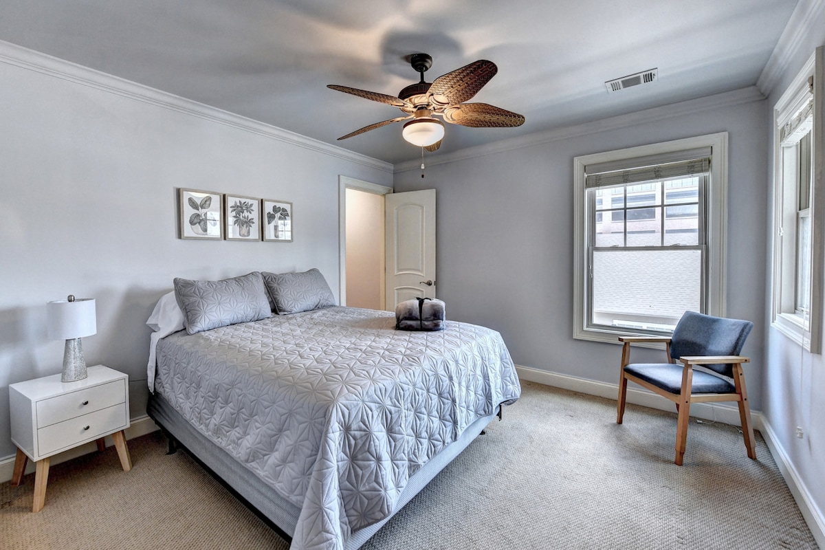 สัมผัสความเงียบสงบของห้องนอนสไตล์โรงแรมสไตล์มินิมอลพร้อมเตียงสีขาวที่สะดวกสบายเก้าอี้และแสงธรรมชาติที่อุดมสมบูรณ์จากหน้าต่างมอบการพักผ่อนที่เงียบสงบและอบอุ่น