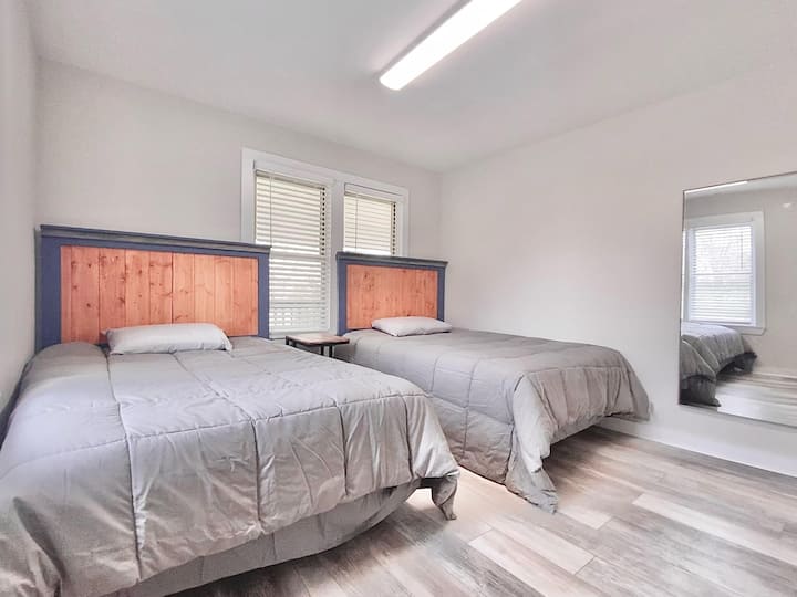 Საძინებელი 2 სრული ზომის საწოლით, სააბაზანო, რომელიც მდებარეობს დარბაზის გასწვრივ