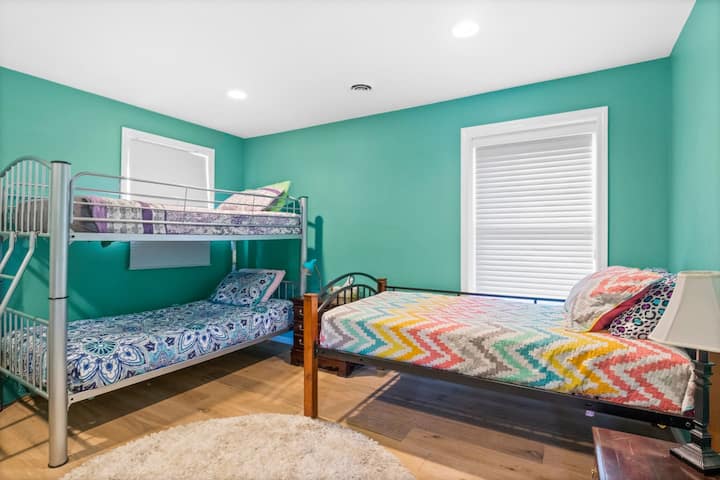 Спалня с единично двуетажно легло, самостоятелно единично легло и прозорци, предлагащи възхитителна гледка.