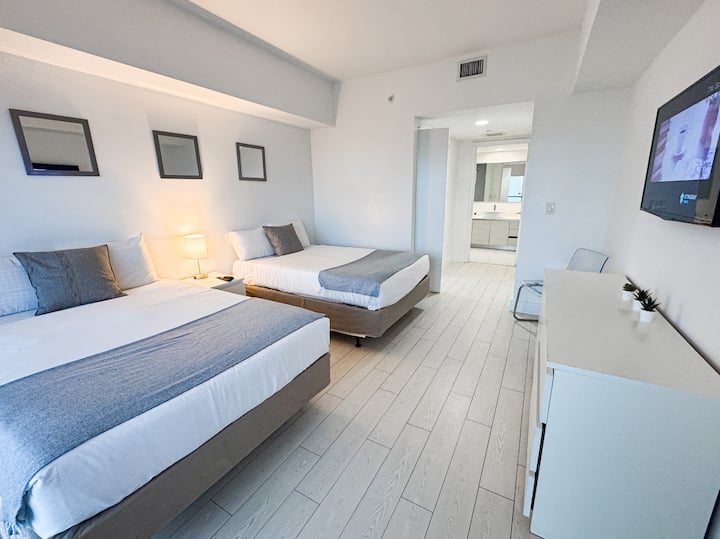 Dve samostatné postele s dekoratívnym umením a teplým osvetlením.