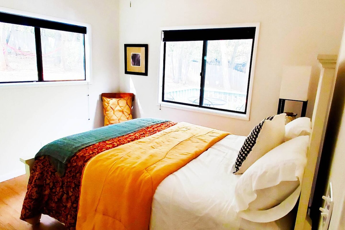 One Queen bed looking out into wooded back yard