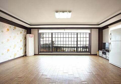 Room with a large window with an ocean view, sunset
