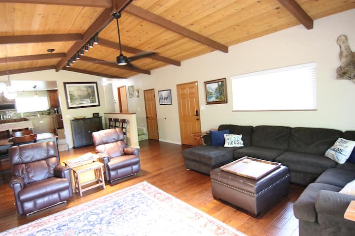 Ლამაზი ხის ჭერი და დიდი ღია საოჯახო ოთახი სამზარეულოდან და სასადილო სივრცეებიდან.