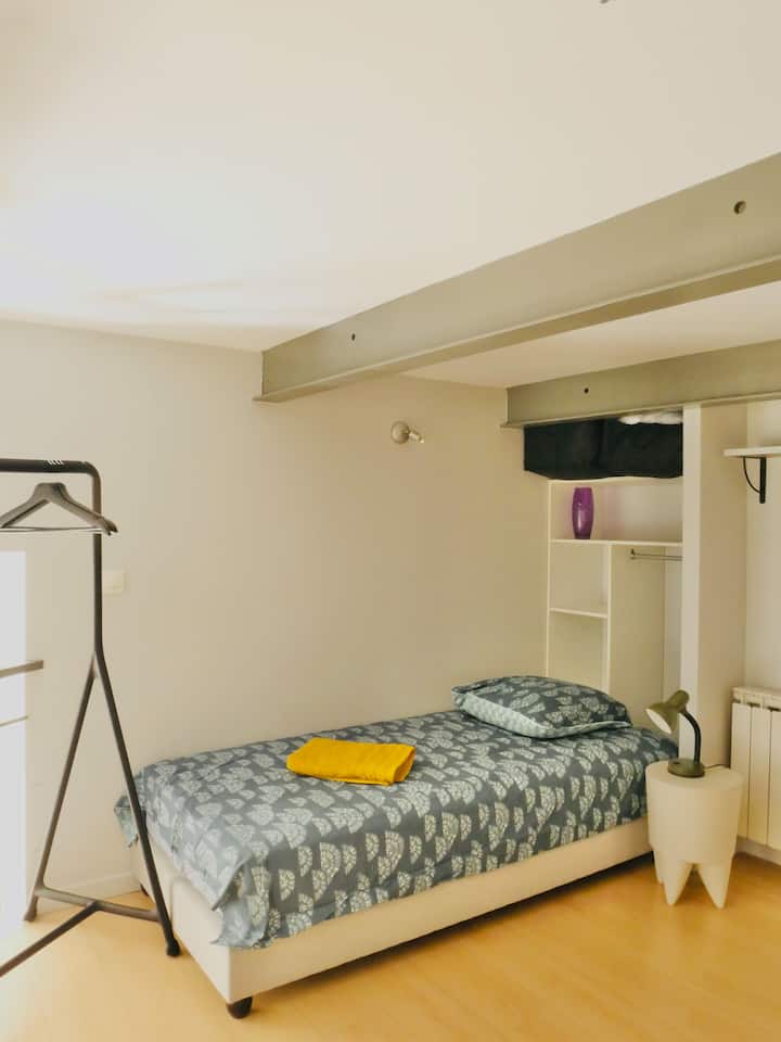 חדר שינה עליון המופרד על ידי וילונות.