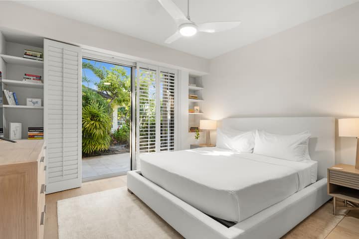 Reposez-vous dans votre chambre sanctuaire au niveau inférieur, avec un patio privé et une vue paisible sur le jardin au-delà des portes vitrées.