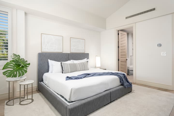 Laissez-vous envelopper par des draps d'un blanc éclatant sur votre lit gris taille king (anciennement un lit simple), dans un cadre à l'élégance côtière moderne et aux touches tropicales.