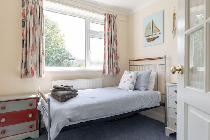 Единечна спална соба со голем прозорец со поглед кон градината.  Викендичка за одмор во Сент Елмо, Саутволд, Сафолк